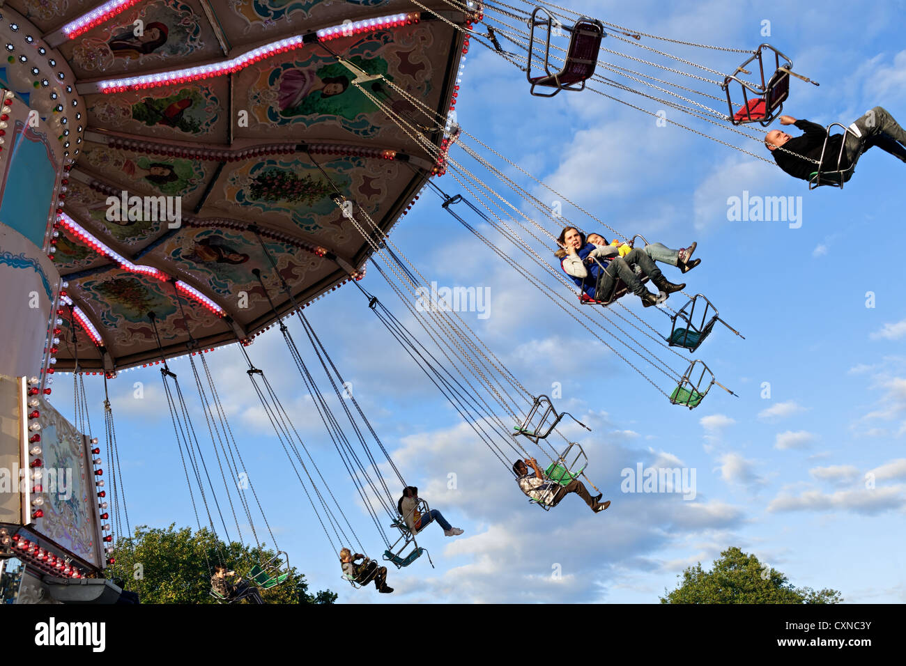 Un carosello gira fairgoers lateralmente a Nottingham storico Fiera d'oca. Nottingham, Regno Unito Foto Stock