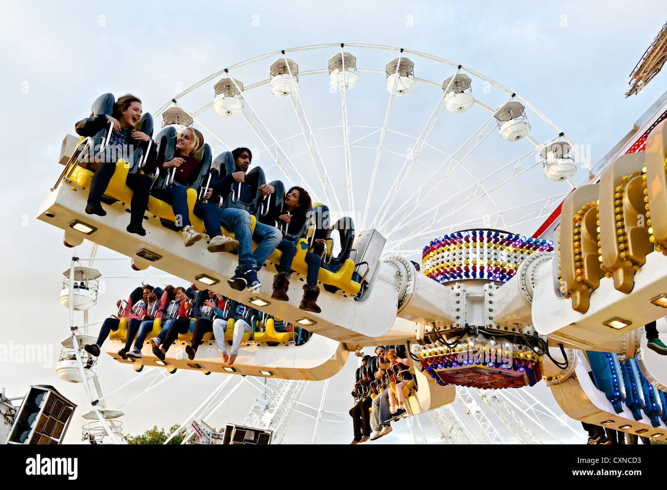 Persone a cavallo sulla sommità Buzz fairground ride a Nottingham storico Fiera d'oca. Foto Stock