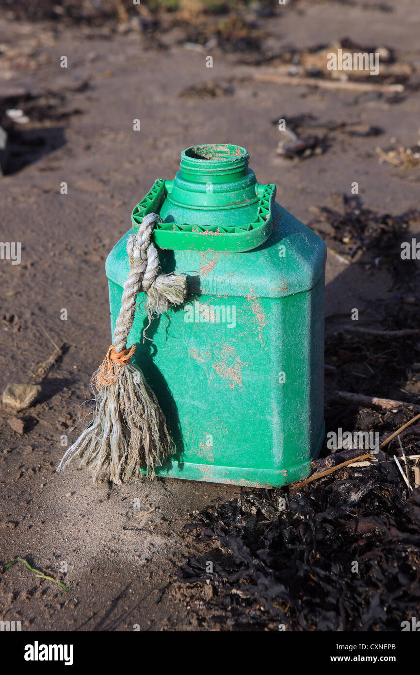 Contenitore in plastica giacente su una spiaggia britannico Foto Stock