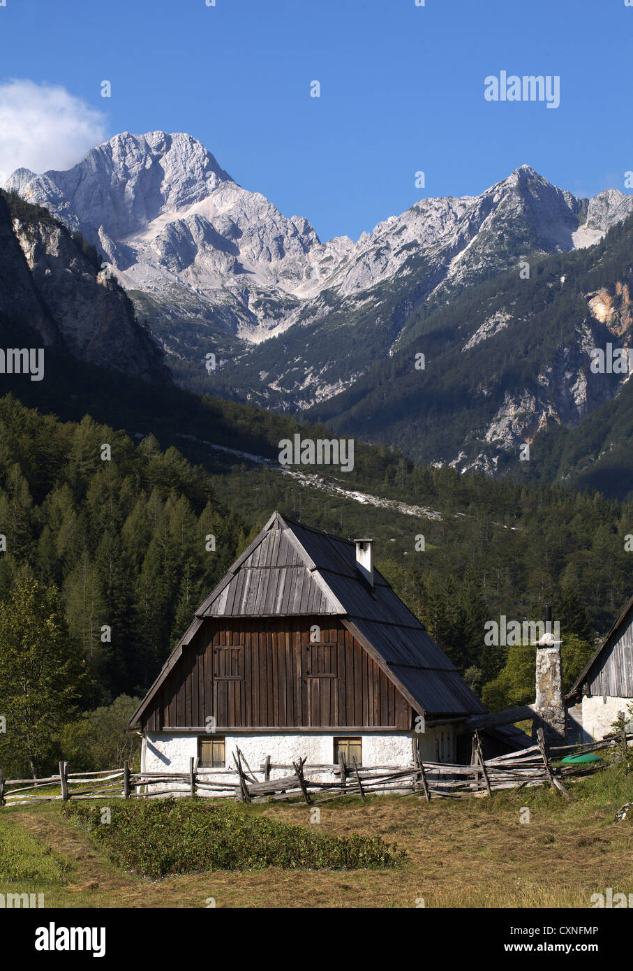 Casa tradizionale in pietra Trenta con tetto in legno e camino esterno con fondo di montagna. Foto Stock