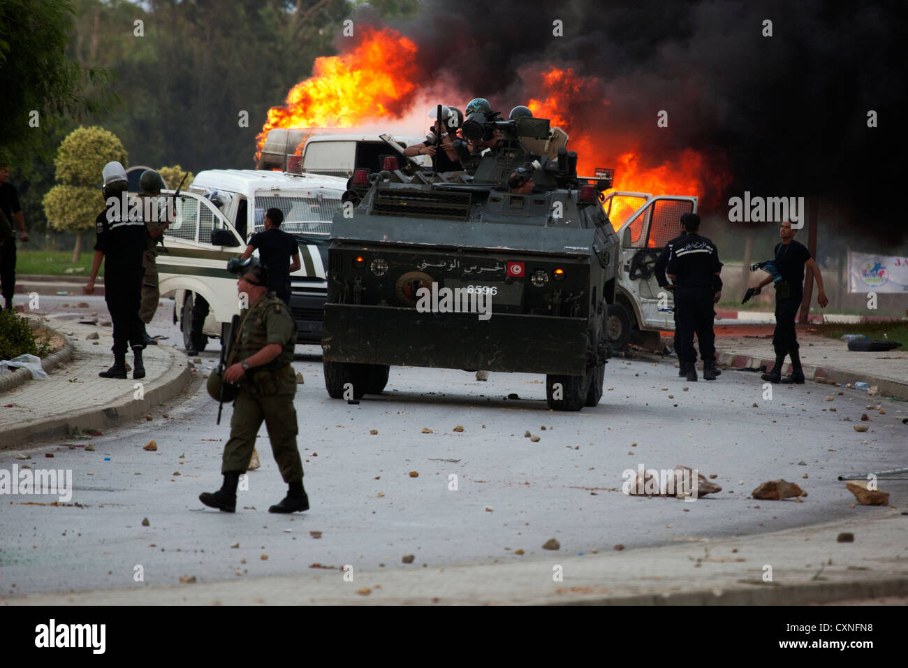 I veicoli della polizia bruciare dopo essere stato colpito da firebombs generata dai rivoltosi durante l'attacco all'ambasciata statunitense di Tunisia Foto Stock