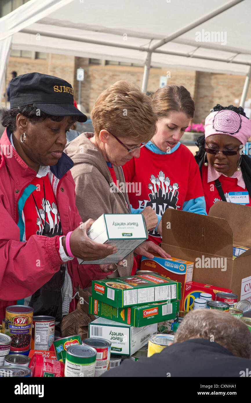 I volontari di ordinare e Pack cibo donato per Banchi Alimentari e mense Foto Stock