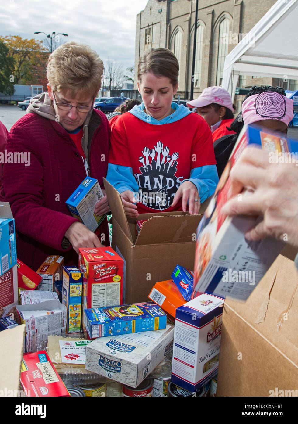 I volontari di ordinare e Pack cibo donato per Banchi Alimentari e mense Foto Stock