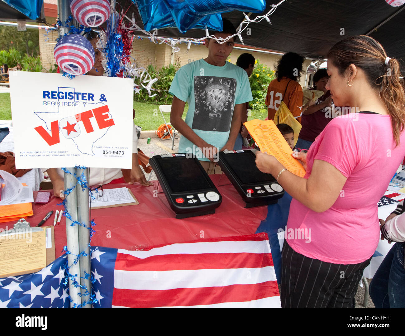 La registrazione degli elettori stand a una chiesa outdoor festival di Austin, Texas include il voto elettronico dimostrazione della macchina Foto Stock