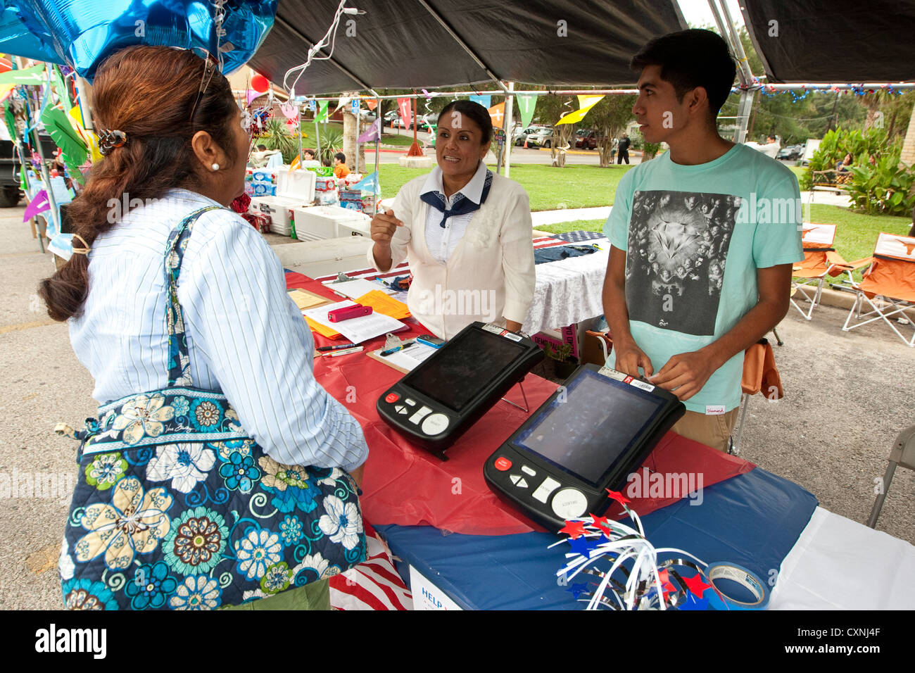 La registrazione degli elettori stand a una chiesa outdoor festival di Austin, Texas include il voto elettronico dimostrazione della macchina Foto Stock