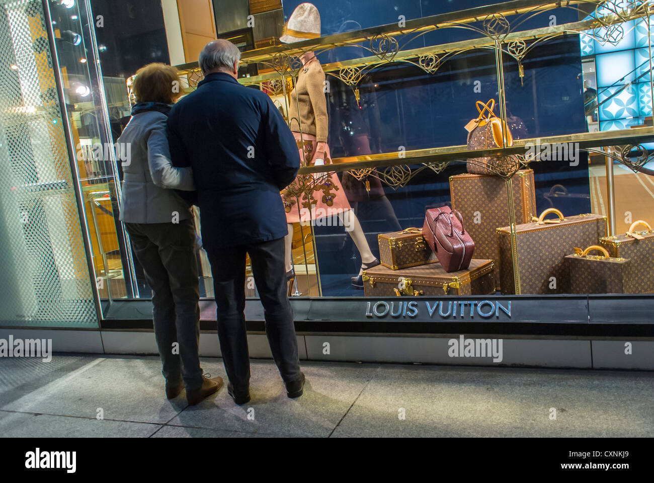 New York, Street Scenes, Couple Shop esposizione vetrina anteriore,  Shopping, Fifth Avenue, 59th Street, 'Louis Vuitton', LVMH Luxury Store,  Manhattan Sidewalk, notte, negozio di abbigliamento donne ricche Foto stock  - Alamy