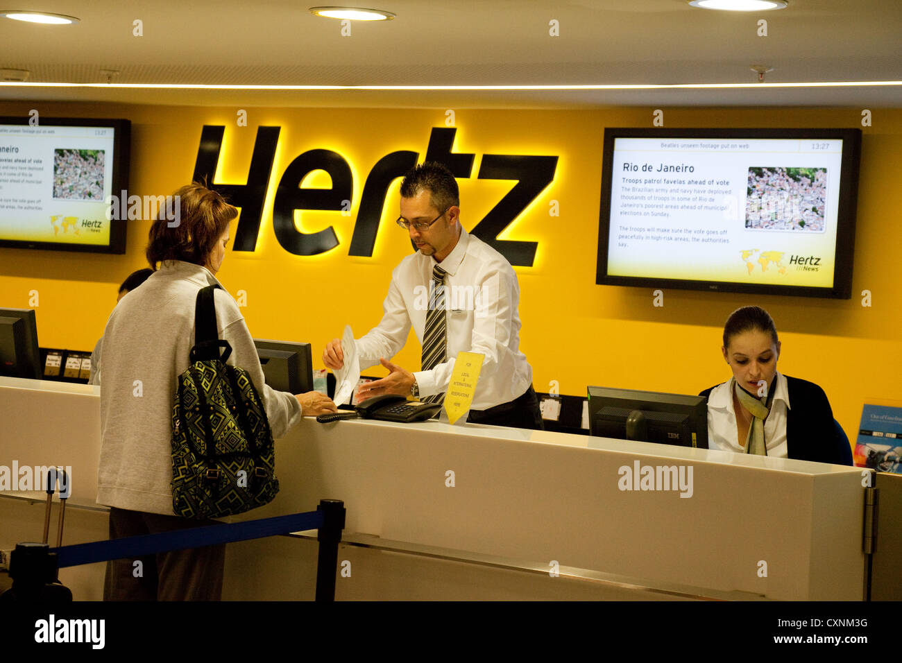 Persone di noleggiare un auto a noleggio auto Hertz escursioni, aeroporto di Zurigo, Svizzera Europa Foto Stock