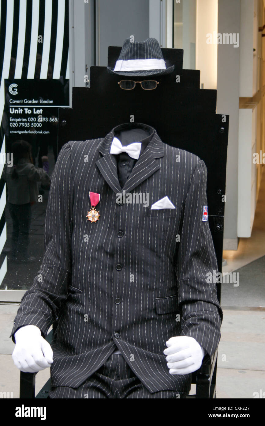 Un Animatore Street a Londra REGNO UNITO vestito come un uomo invisibile che indossa un abito con gli occhiali, guanti e un cappello. Foto Stock