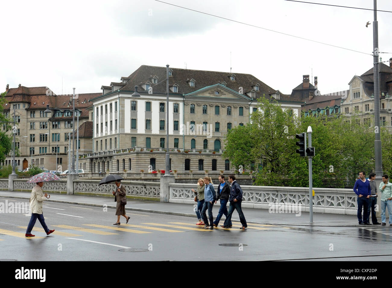 Le persone che attraversano la strada vicino al ponte sul fiume Limmat a Zurigo. Aveva piovuto di recente ed è stata una vacanza, in modo che meno persone intorno a. Foto Stock