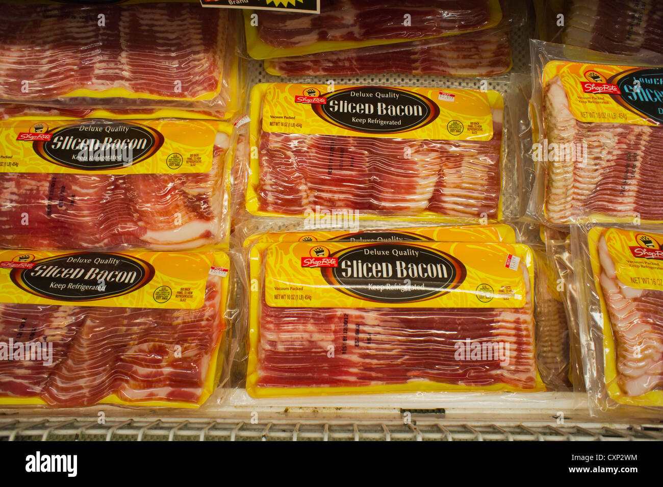 Pacchetti di house brand bacon sono visti in un supermercato raffreddatore in New York Foto Stock