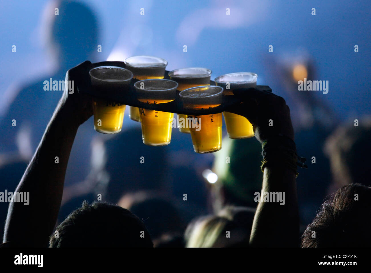 L'atmosfera durante il live concerto rock e uomo portando pinte di birra in bicchieri di plastica per gli amici tra gli spettatori / folla, Belgio Foto Stock