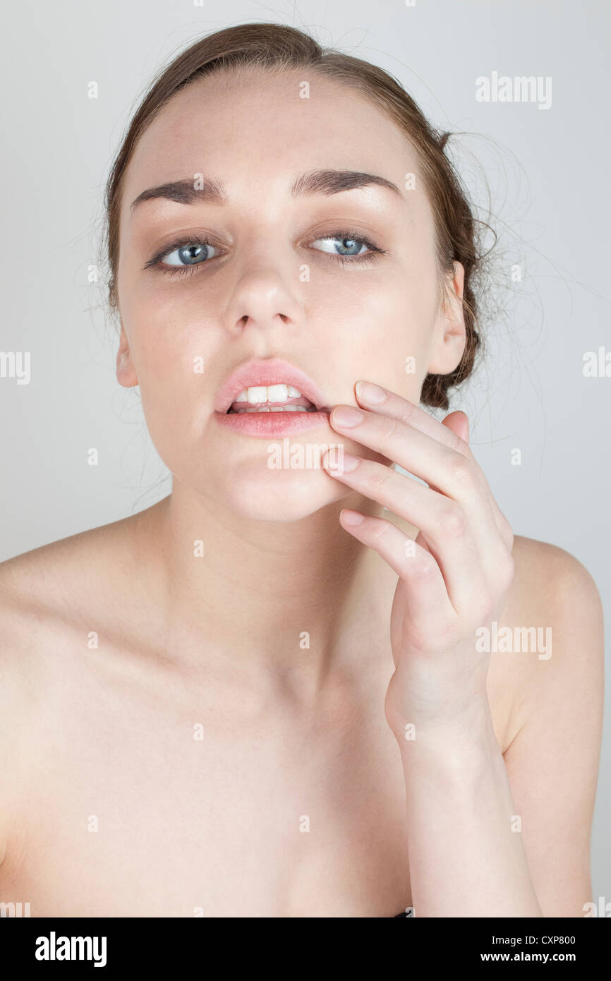 Donna che guarda la sua faccia nello specchio Foto Stock