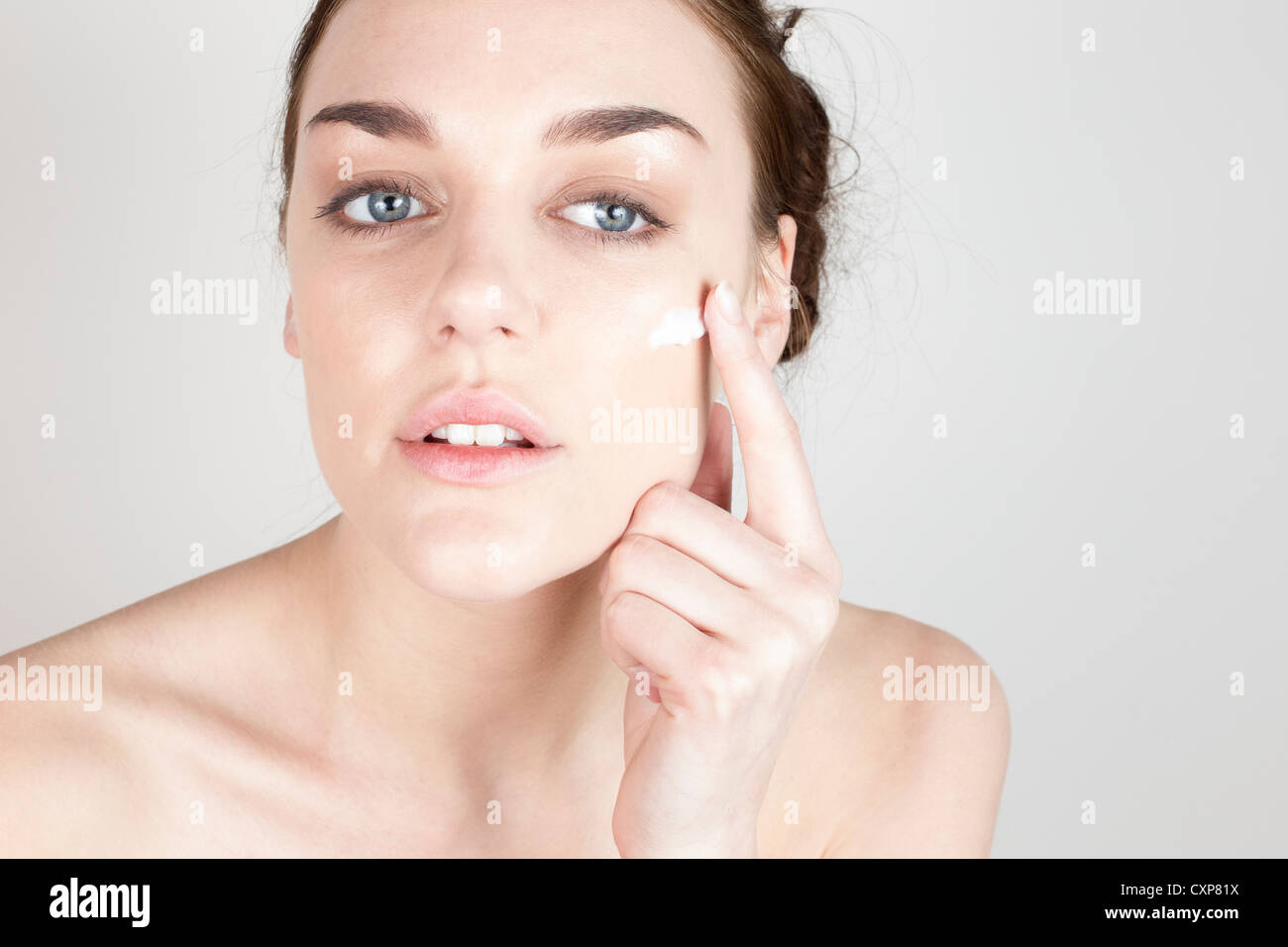 Donna l'applicazione di crema per il viso Foto Stock