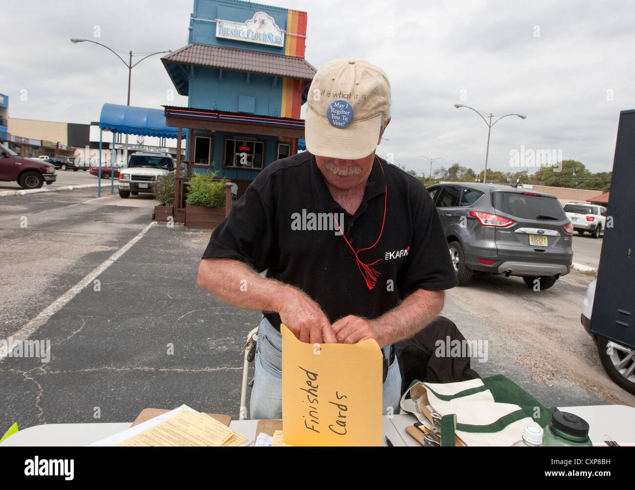 Maschio bianco elettore volontario del cancelliere imposta la tabella di registrazione di Austin, TX, shopping center Parcheggio prima della prossima elezione. Foto Stock