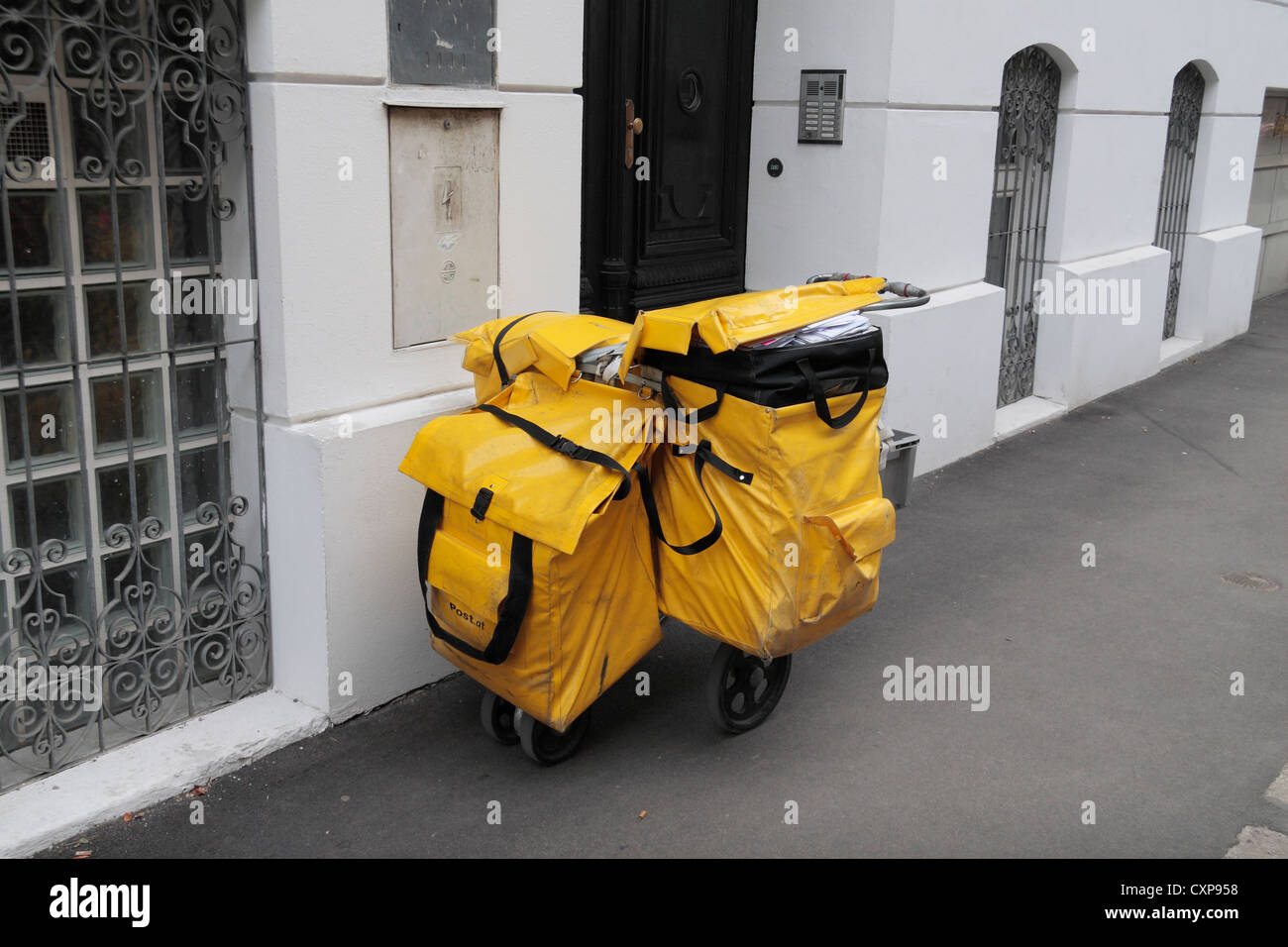 Un pesantemente caricato postino austriaco il carrello/carrello parcheggiato al di fuori di una proprietà di Vienna in Austria. Foto Stock