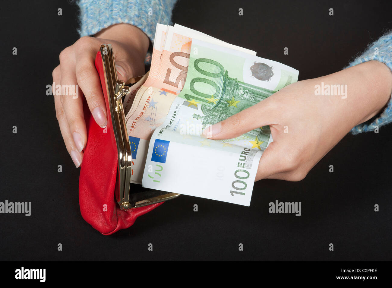 Donna di mani portamonete rosso contenente alta denominazione delle banconote in euro Foto Stock