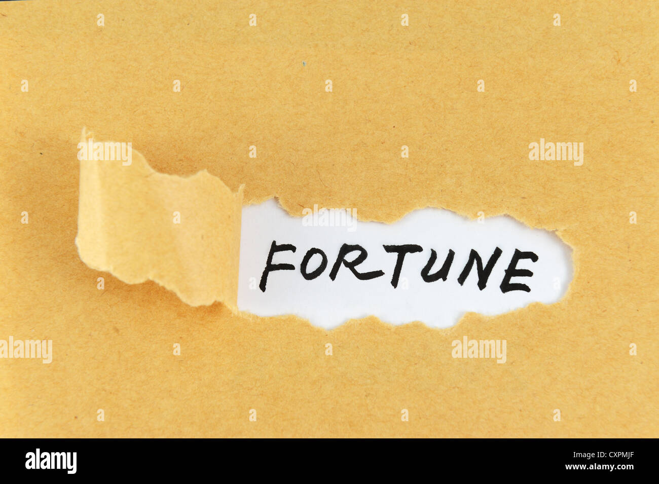 Carta strappata con fortune parola dietro di essa Foto Stock
