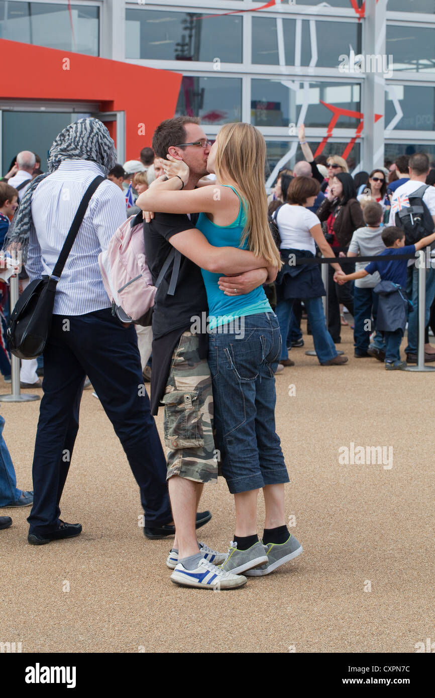 Persone (Homo Sapiens). Coppia giovane abbracciando e baciando, in pubblico. Parco Olimpico. Londra. In Inghilterra. Regno Unito Foto Stock