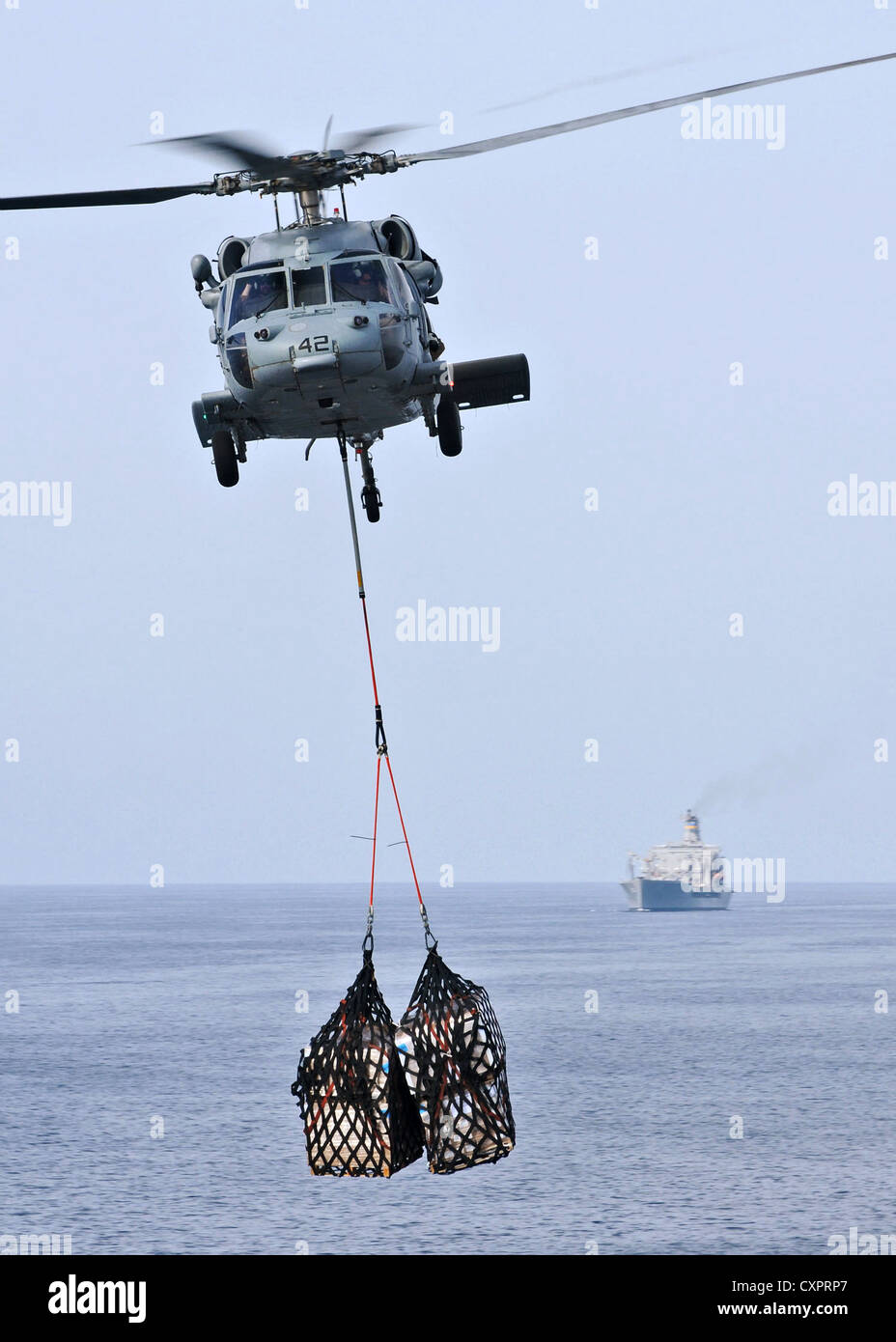 US Navy MH-60S Sea Hawk elicottero offre un carico per il ponte di volo a bordo del trasporto anfibio dock nave USS New York durante un rifornimento in mare Ottobre 2, 2012 nel Golfo di Aden. Foto Stock