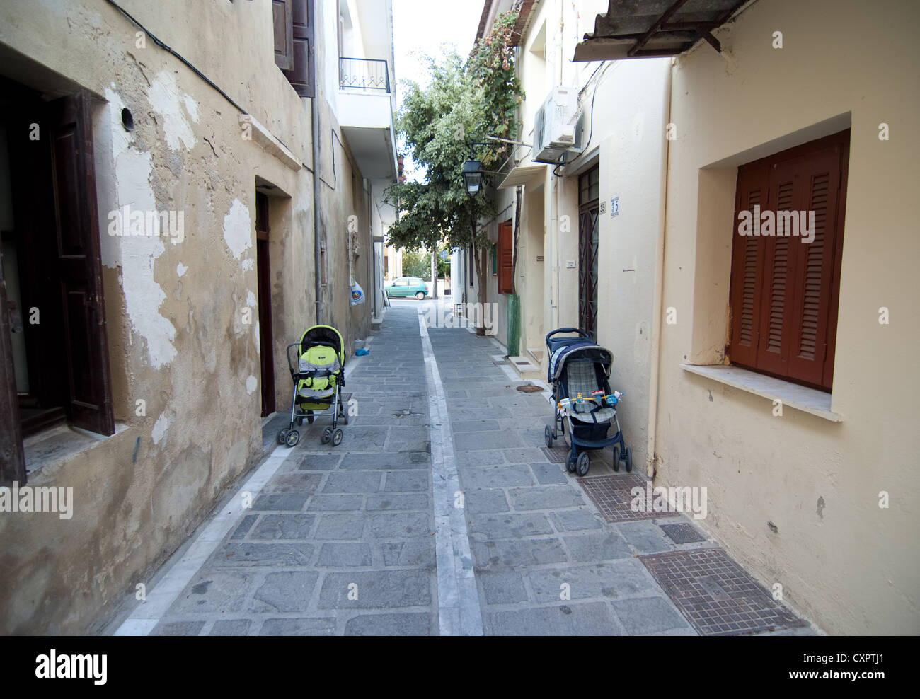 Due bambini di buggy in una strada stretta nella città di Rethymnon sull isola di Creta Foto Stock