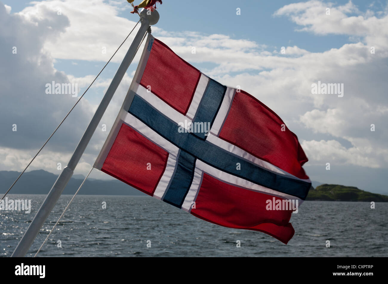 La bandiera norvegese battenti nel vento sul retro di una nave passeggeri in Stavanger, Norvegia. Foto Stock