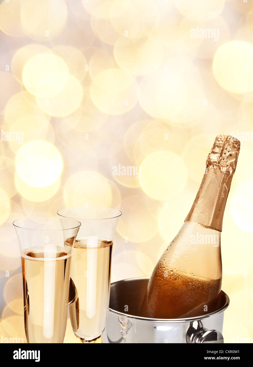 Due bicchiere di champagne con bottiglia in un giallo la sfocatura dello sfondo. Foto Stock