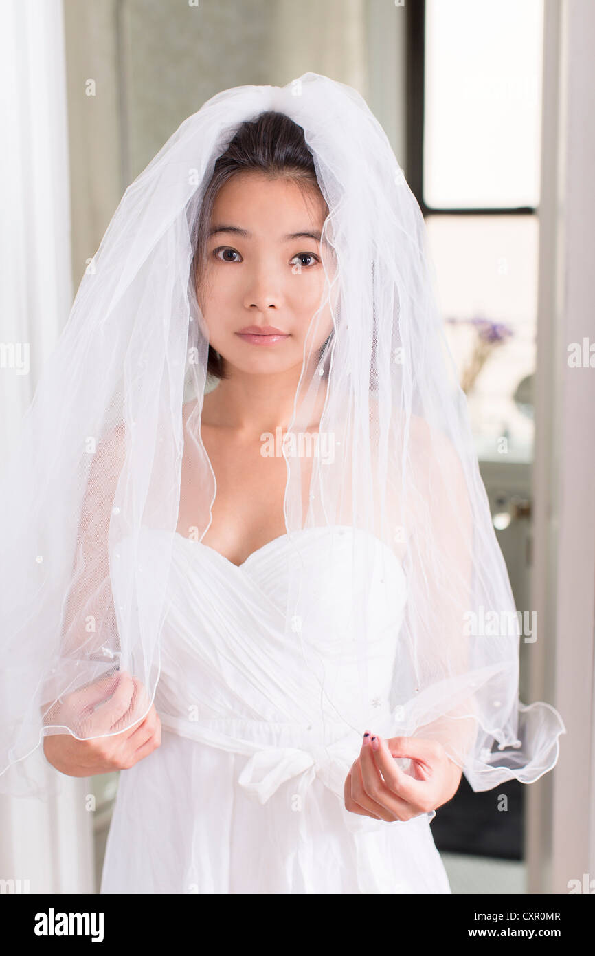 Giovane donna che indossa abiti da sposa con velo Foto stock - Alamy