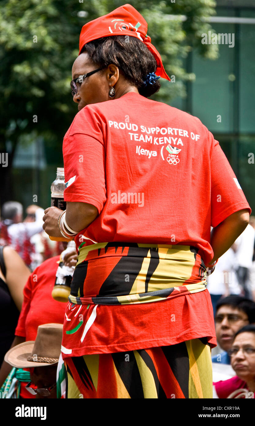 Una femmina patriottico sostenitore del Kenya team olimpico dancing in luminosi colori rosso Londra Inghilterra Europa Foto Stock