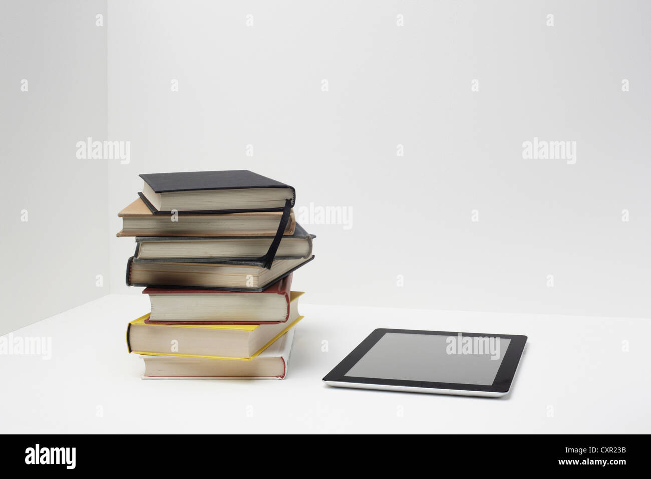 Pila di libri con tavoletta digitale Foto Stock