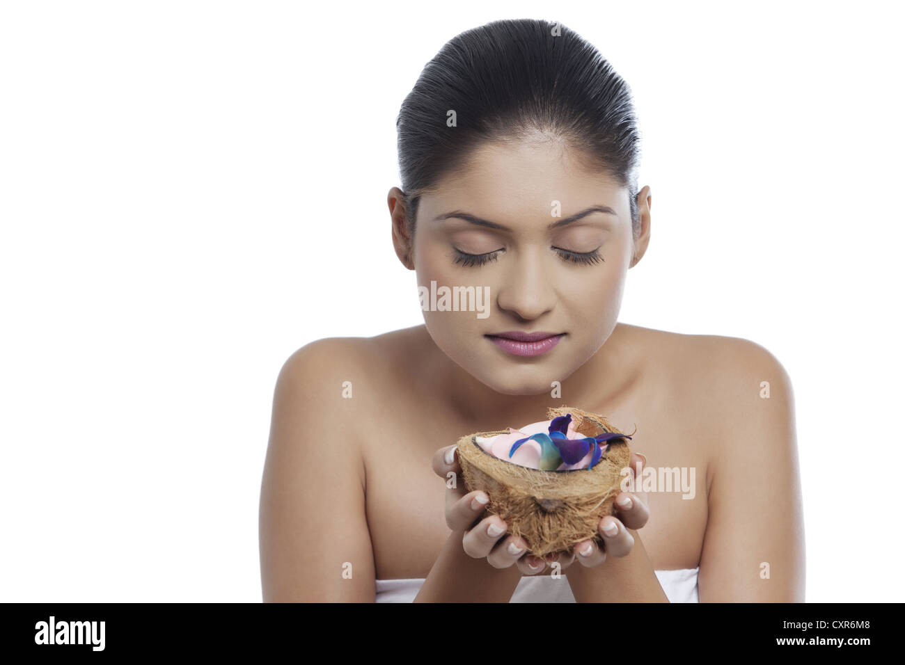 Close-up di giovane donna tenendo il cocco su sfondo bianco Foto Stock