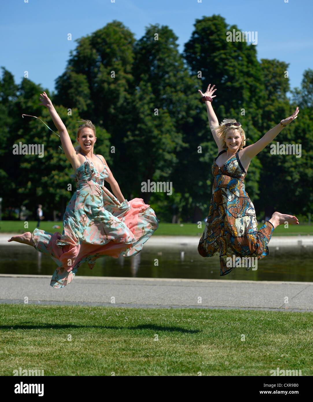 Due donne, fidanzate, salti di gioia per l'aria, la gioia di vivere, Schlosspark, il parco del castello di Stoccarda, Baden-Wuerttemberg Foto Stock