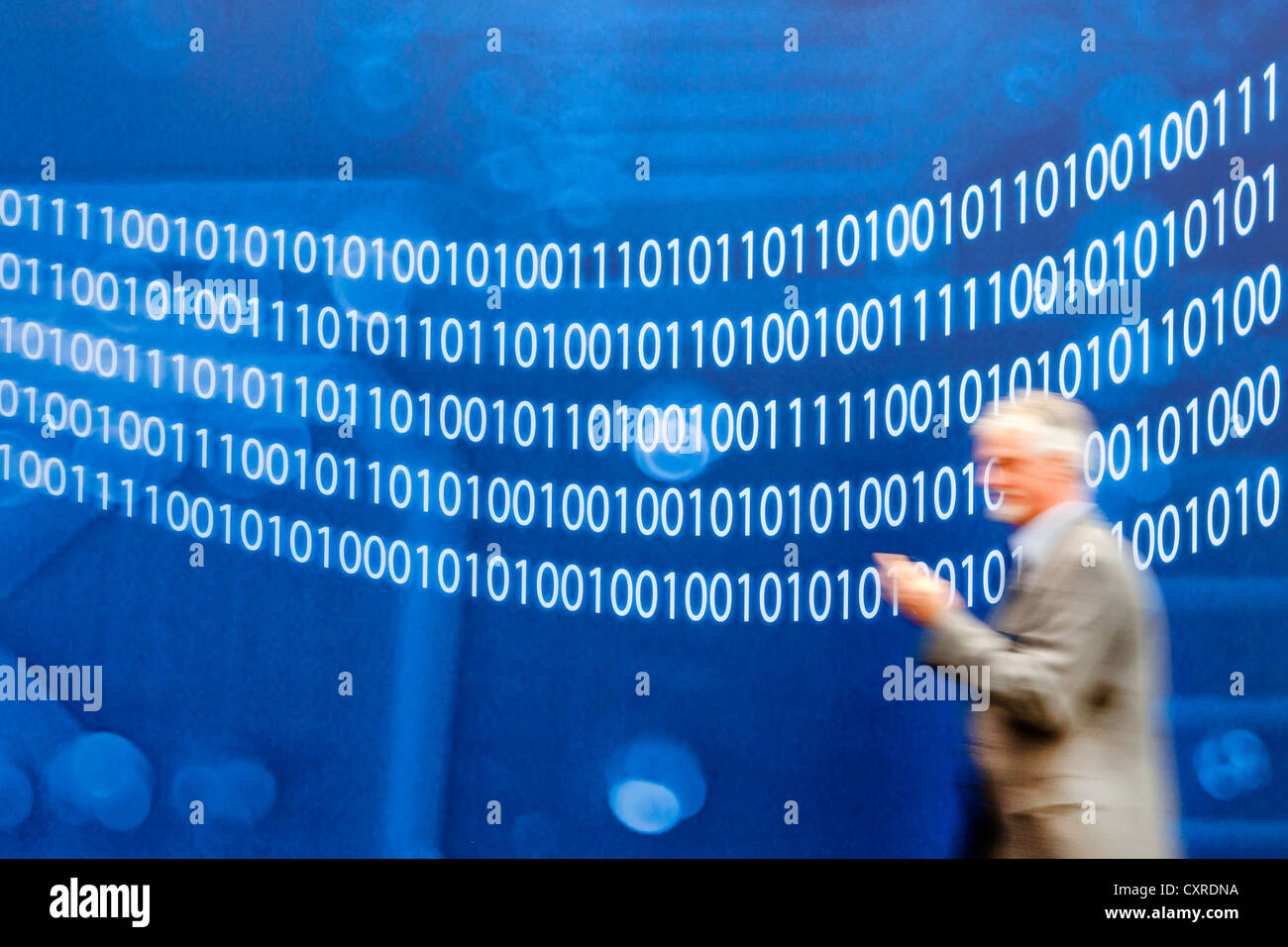 Uomo a camminare lungo una parete con numeri binari, il codice binario i numeri zero e uno, CeBIT international computer Expo di Hannover Foto Stock
