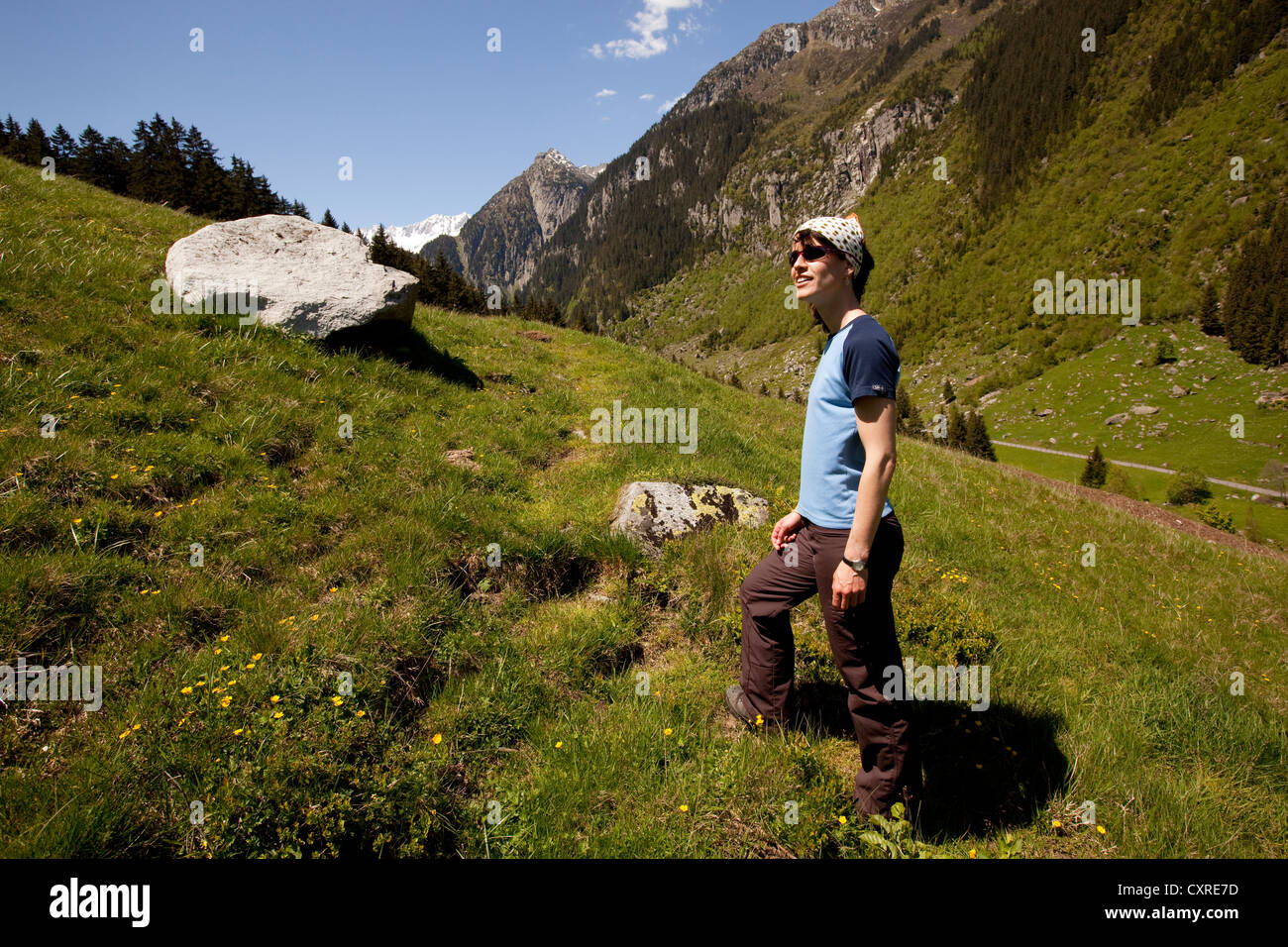 Giovane donna escursionismo, prati e montagne alle spalle, vicino a Goeschenen, Goescheneralpsee, Reusstal, la valle della Reuss nel Cantone di Uri Foto Stock