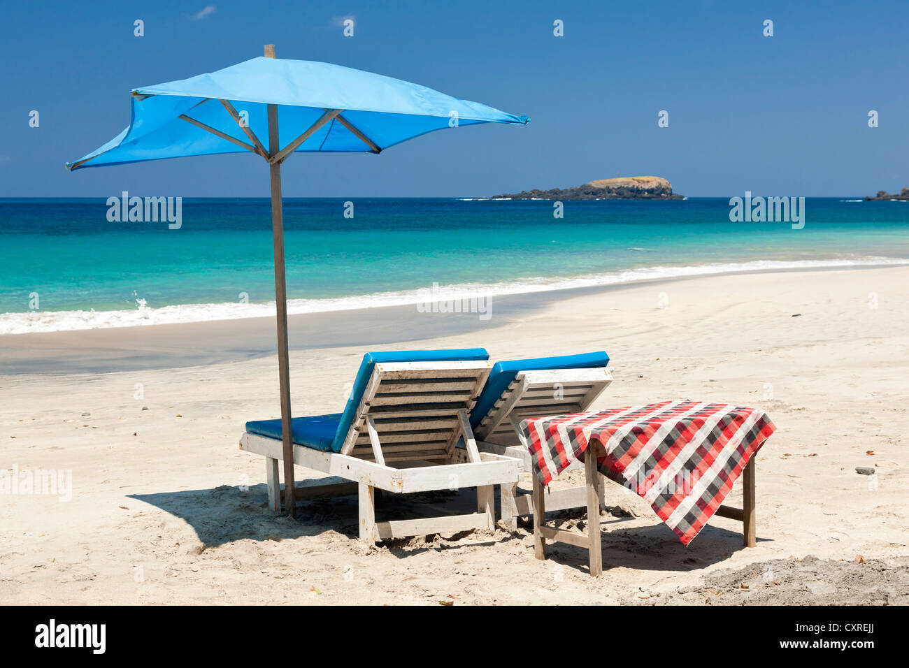 Sedie a sdraio e un ombrellone in spiaggia, Pasir Putih o la spiaggia di sabbia bianca, a est di Candi Dasa, East Bali, Bali, Indonesia Foto Stock