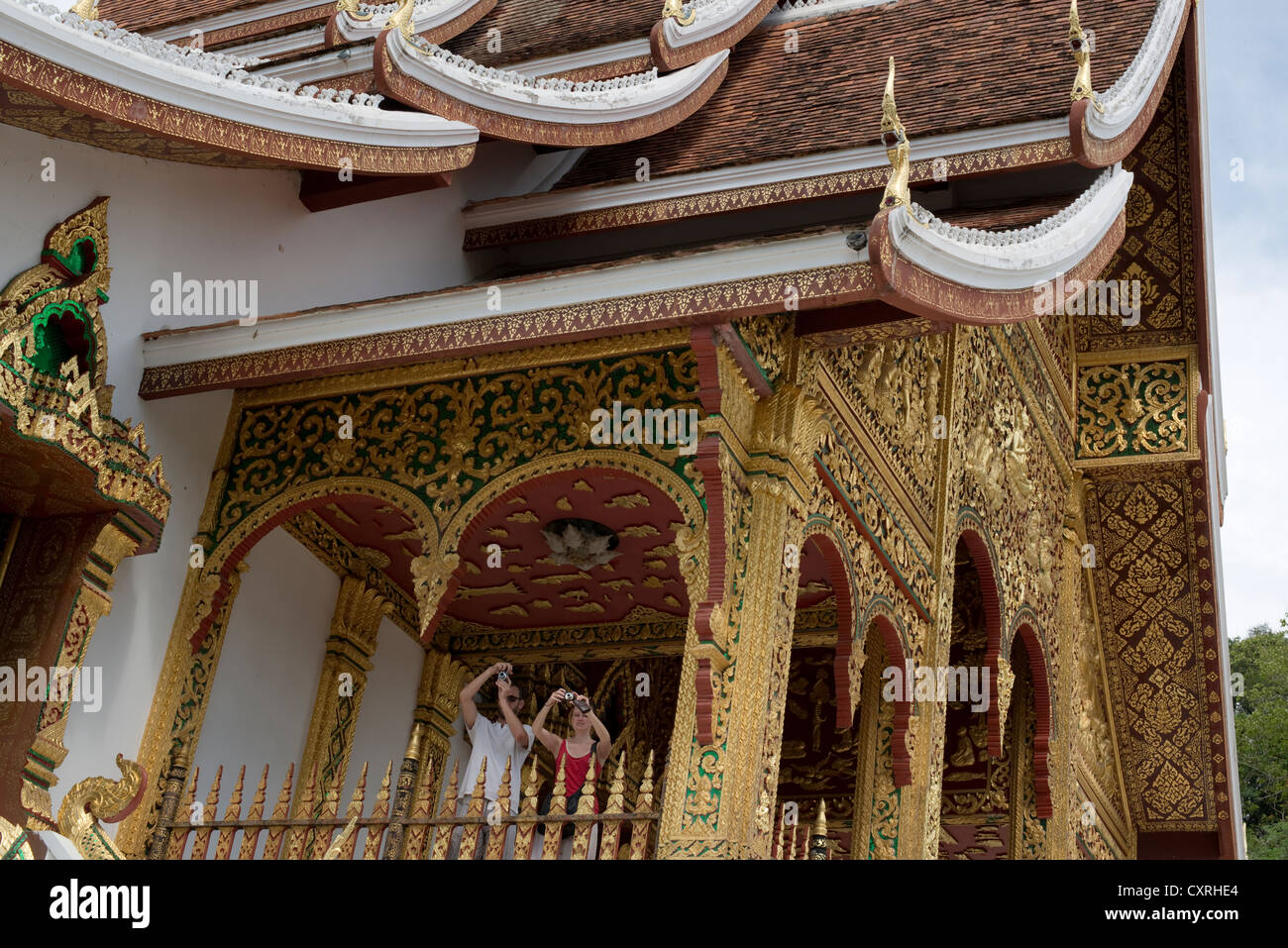 I turisti scattare foto da un tempio nei giardini del Palazzo Reale a Luang Prabang, Laos Foto Stock