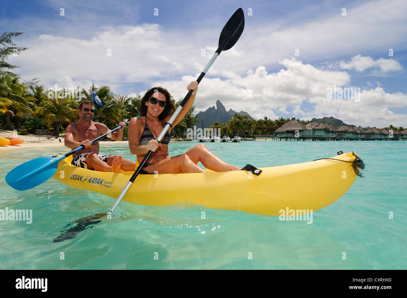 Turista giovane in un kayak, St. Regis Bora Bora Resort, Bora Bora, Leeward Islands, Isole della Società, Polinesia Francese Foto Stock