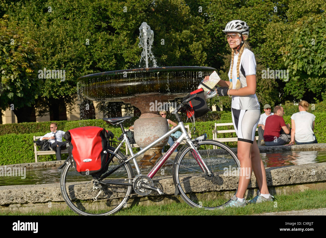 Donna con il suo touring bike nel Hofgarten, Corte Giardino, Monaco di Baviera, Baviera, Baviera, Germania, Europa Foto Stock