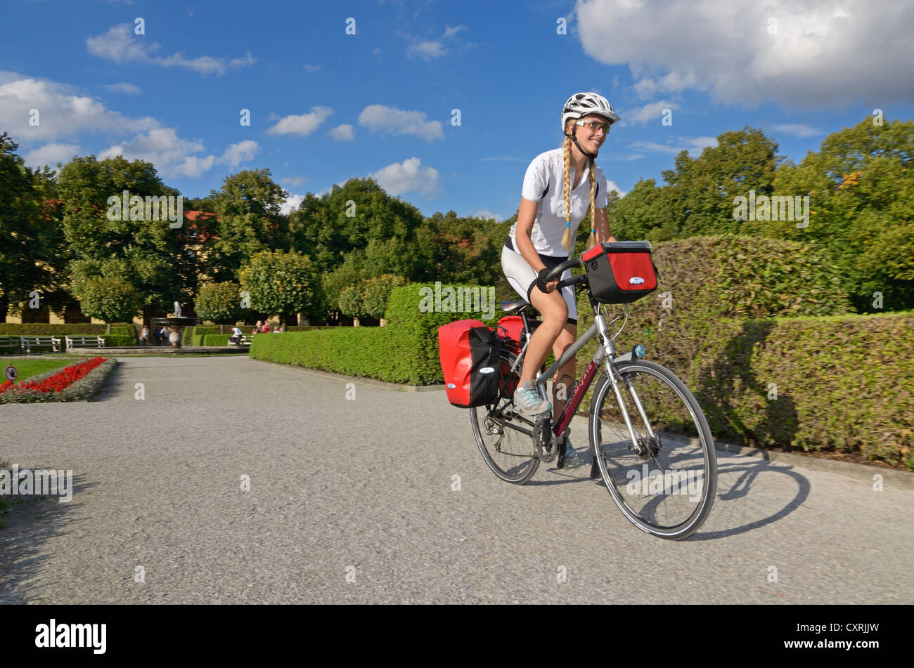 Equitazione donna sua touring bike attraverso il Hofgarten, Corte Giardino, Monaco di Baviera, Baviera, Baviera, Germania, Europa Foto Stock