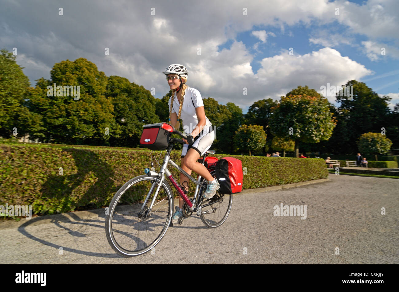Equitazione donna sua touring bike attraverso il Hofgarten, Corte Giardino, Monaco di Baviera, Baviera, Baviera, Germania, Europa Foto Stock