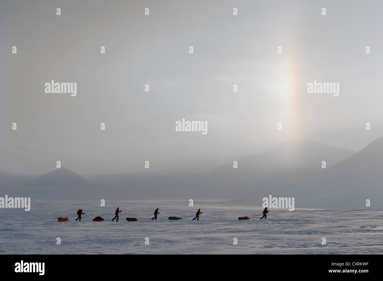 Gruppo di escursionisti di sci con pulkas su un gelido ghiacciaio con sundog o phantom sun, alo, Hayesbreen, Spitsbergen, Svalbard, Norvegia Foto Stock