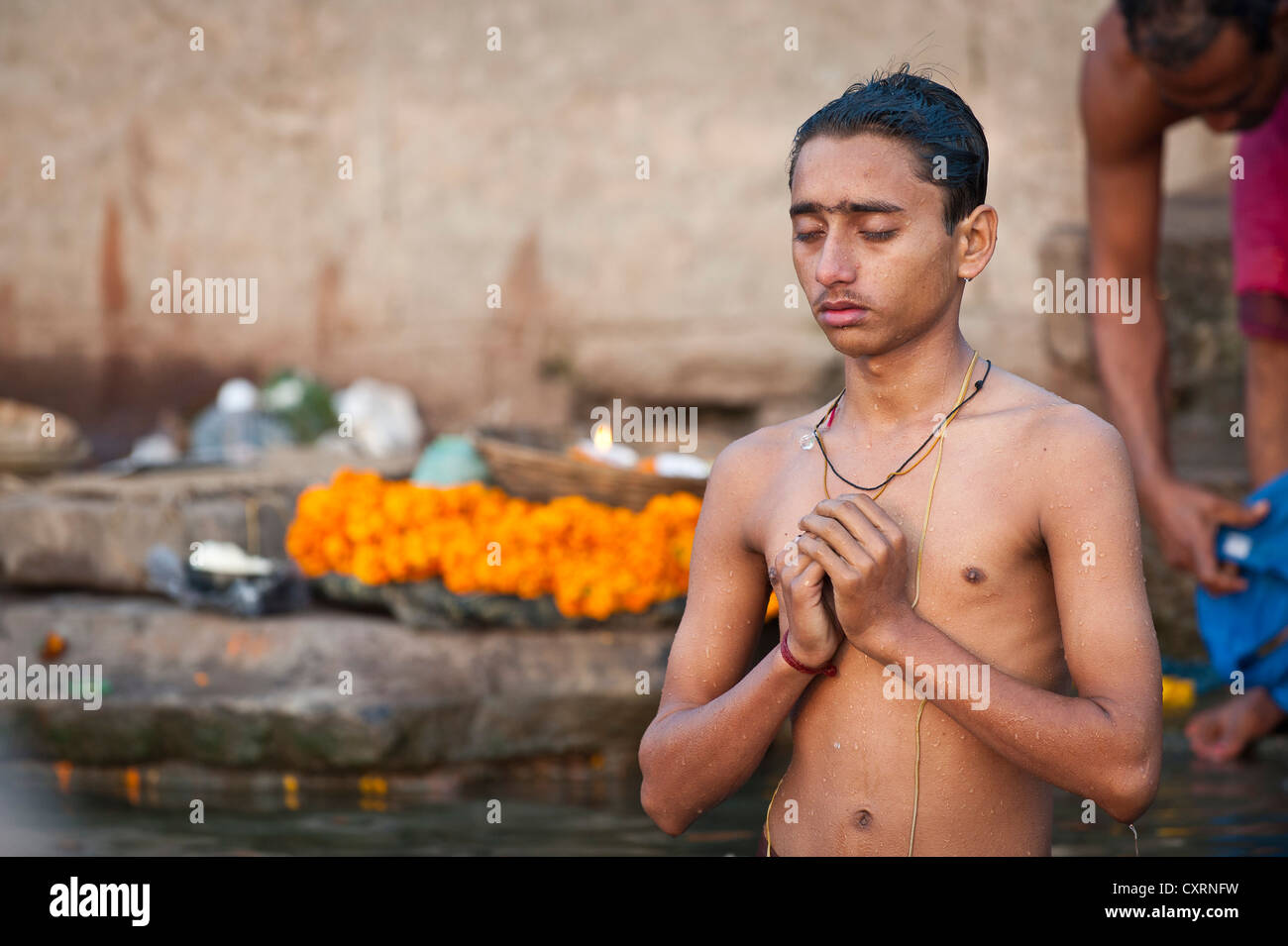 Giovane uomo indù con gli occhi chiusi durante la preghiera del mattino, il Gange, Varanasi, Benares o Kashi, Uttar Pradesh, India, Asia Foto Stock