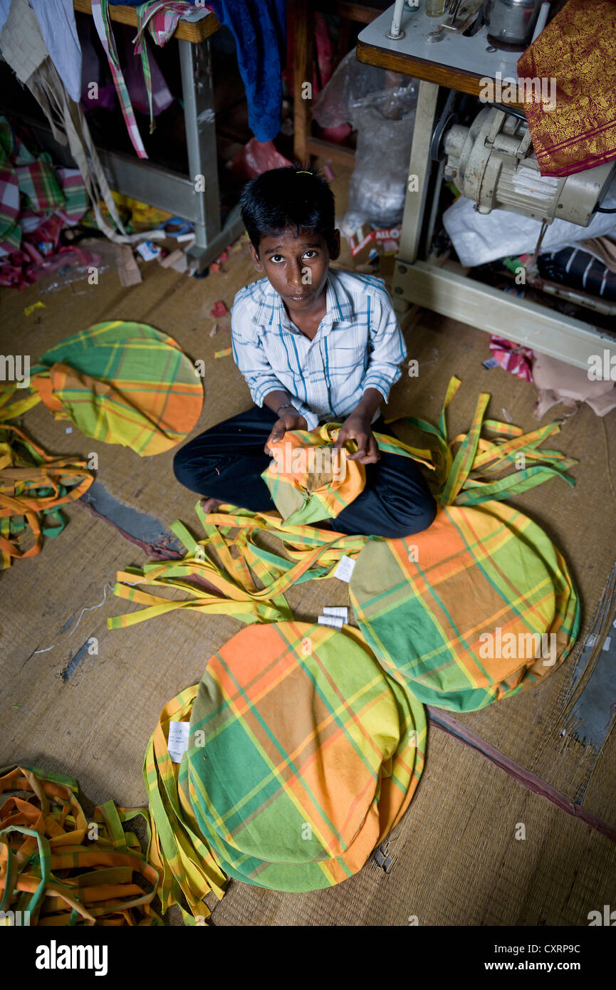 Il ragazzo, circa 13 anni, cucito insieme i cuscini colorati in casa sua, Karur, Tamil Nadu, India meridionale, India, Asia Foto Stock