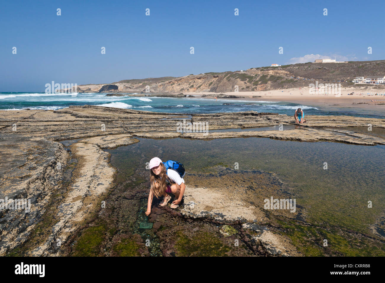 Ragazza che gioca su un pool di marea, Monte Clerigo beach, costa atlantica, Algarve, Portogallo, Europa Foto Stock