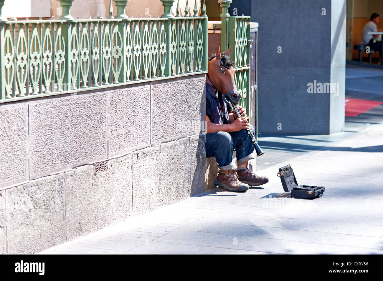 Clarinetto player con una maschera di cavallo giocando in una zona pedonale, Auckland, Isola del nord, Nuova Zelanda Foto Stock