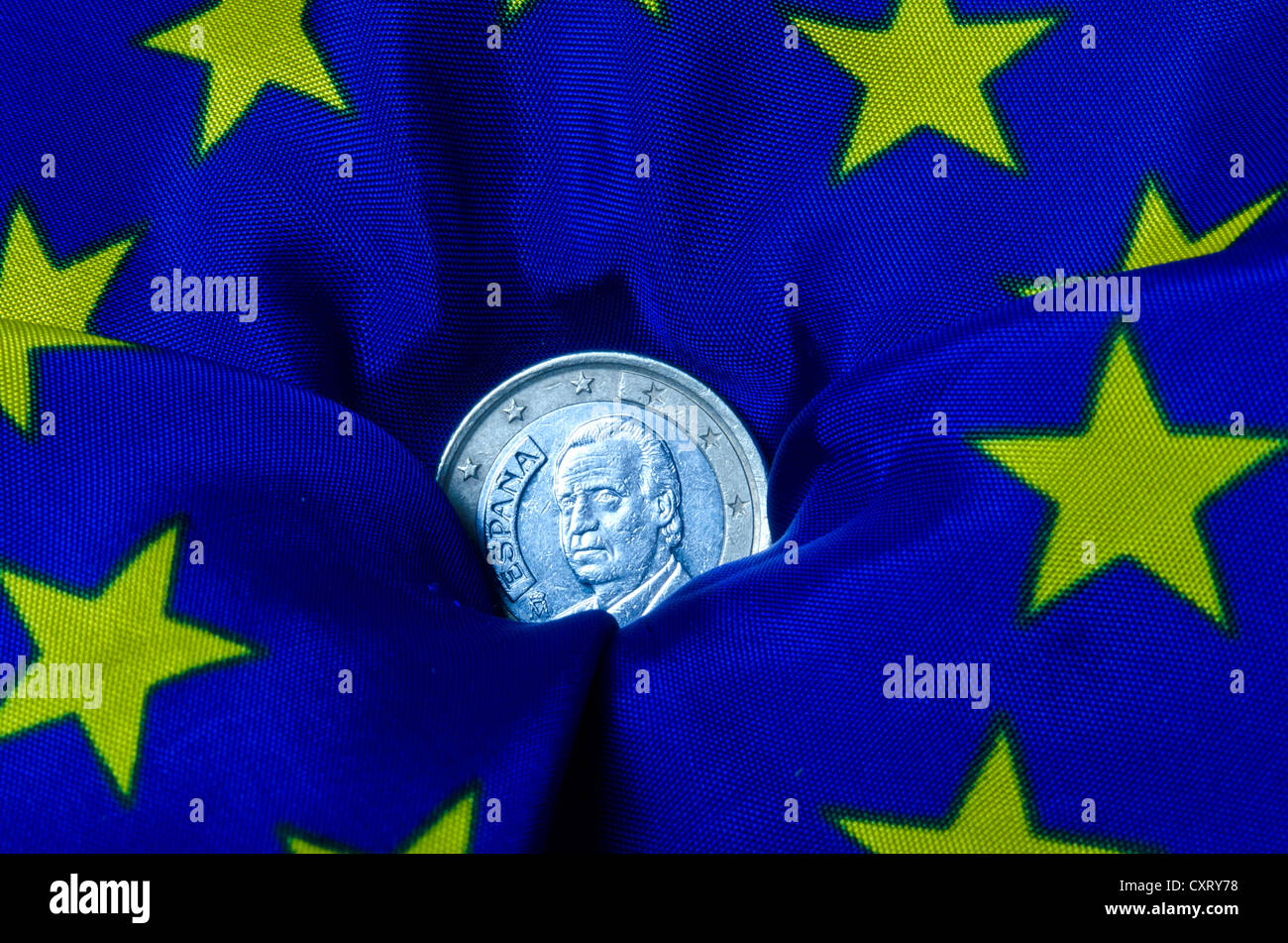Lo spagnolo euro moneta giacente su una bandiera europea, andando verso il basso, immagine simbolica Foto Stock