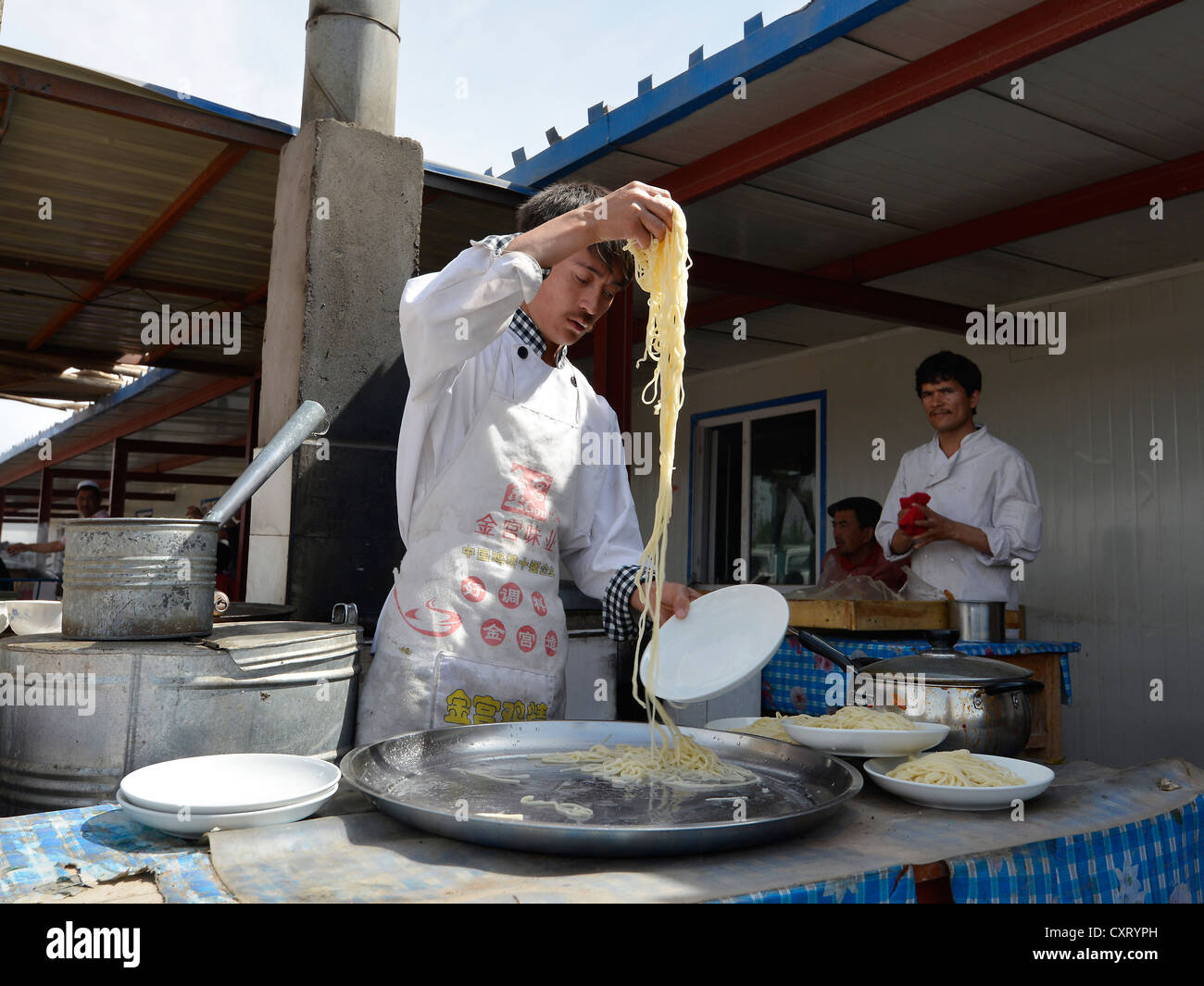 Cookshop, Uyghur rendendo freschi fatti a mano le tagliatelle o la pasta, musulmani uiguri, Silk Road, Uyghur mercato del bestiame, mercato di domenica Foto Stock