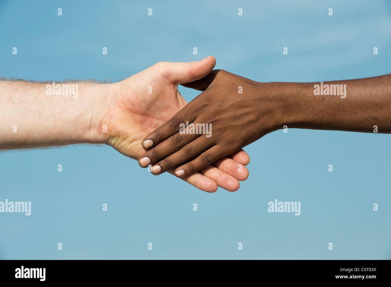 Occidentali e Orientali di agitare a mano contro un cielo blu Foto Stock