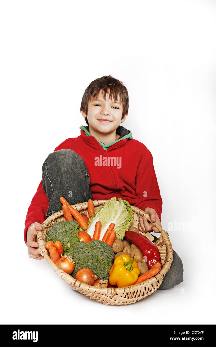 Ragazzo tenendo un cesto di verdure Foto Stock