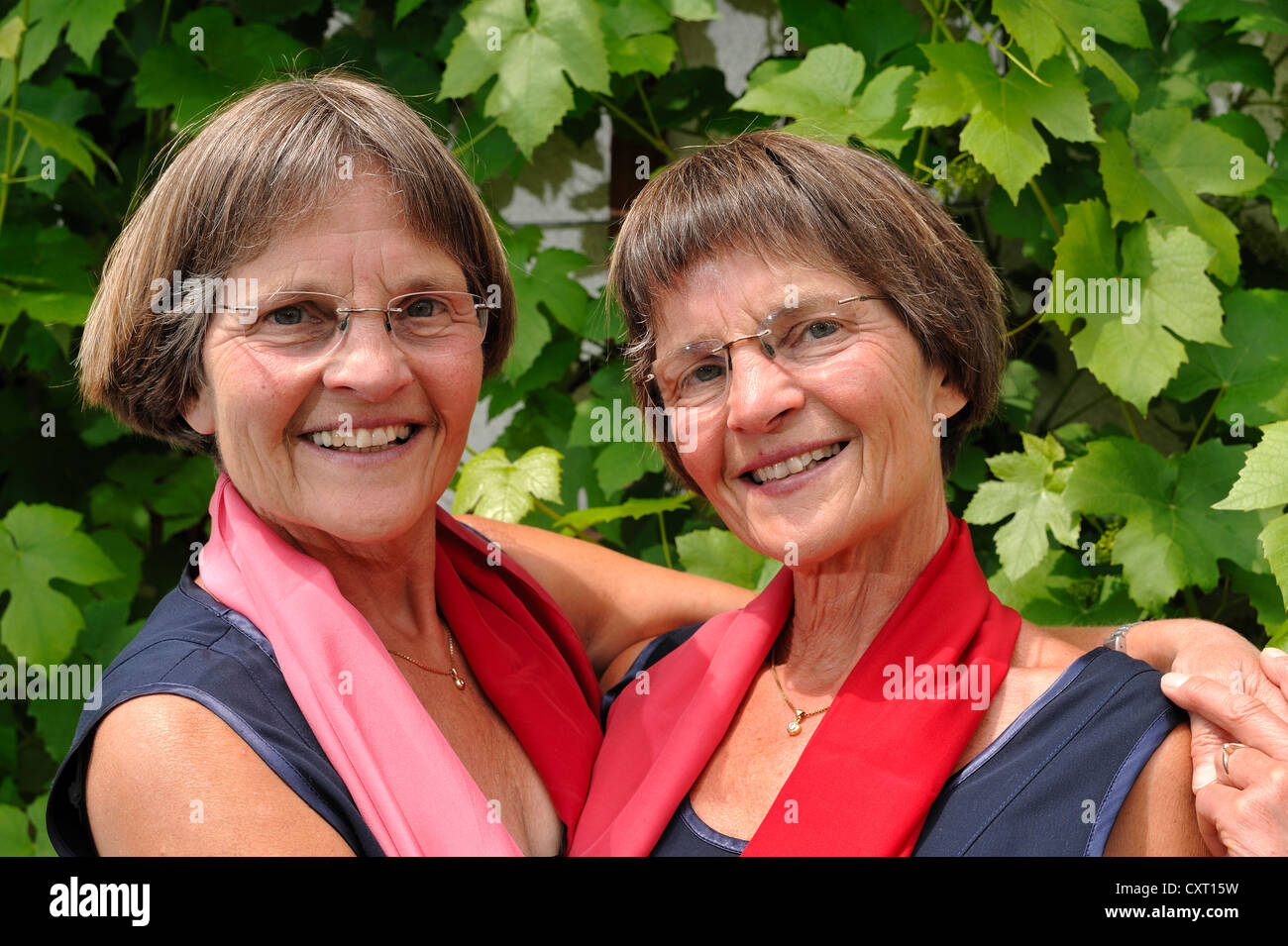 Lusty gemelle, vestiti simili in rosso sciarpe, ritratto Foto Stock
