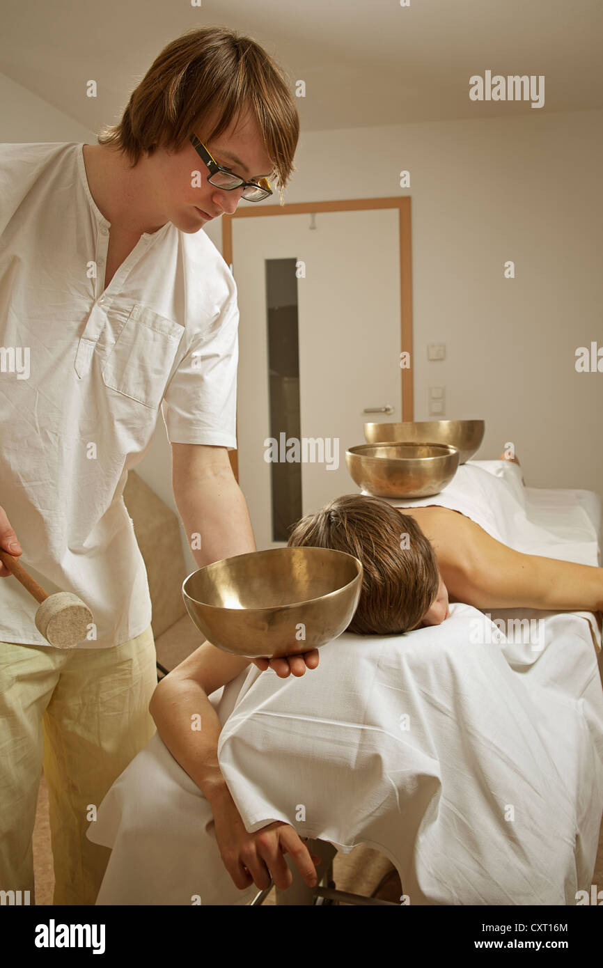 Massaggio terapeuta e paziente ottenere un massaggio sonoro con SINGING BOWLS Foto Stock